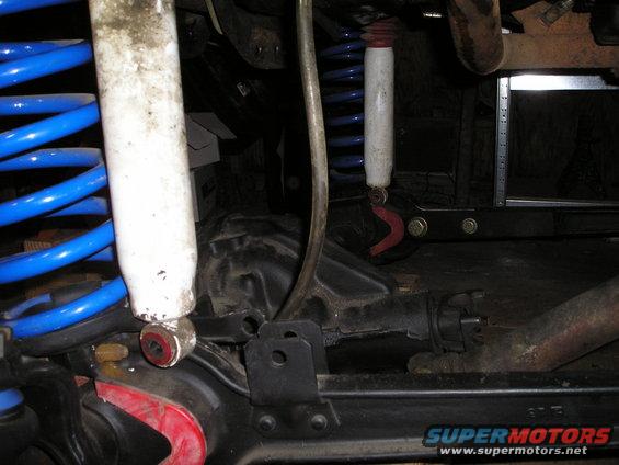 Close-up of blue coil springs and white shock absorbers on a vehicle's suspension