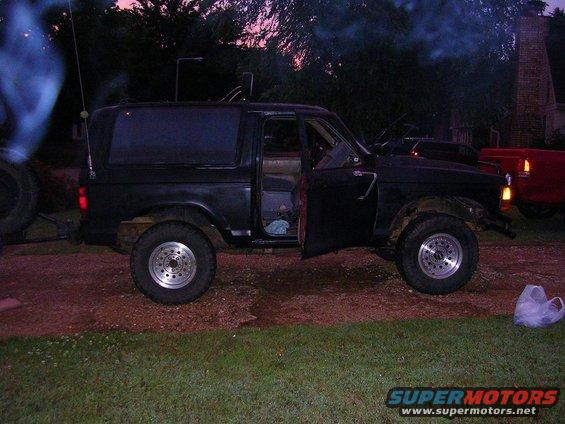 Black SUV parked outside with doors open, smoke coming from the side