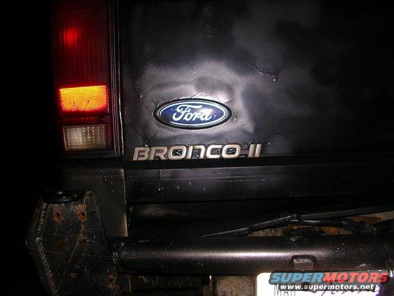 Rear view of a black Ford Bronco II with emblem and taillight visible
