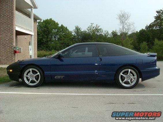 Blue 1995 Ford Probe GT parked outside brick building, front car cover installed
