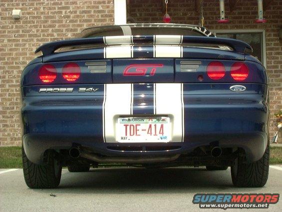 Rear view of blue 1995 Ford Probe GT with white racing stripes and Wisconsin license plate TDE-414