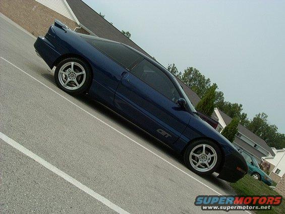 Blue 1995 Ford Probe GT coupe, side view, parked on asphalt with white lines