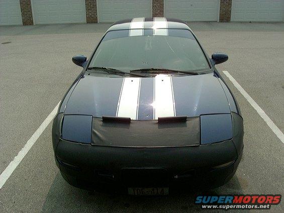 1995 Ford Probe with dual white racing stripes and a black car bra covering the front bumper