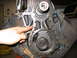 1979 Ford F-150 - A hand points to the timing chain and gears on an engine block.