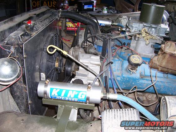 Engine bay with blue engine block, radiator, fan, and a KING OFF-ROAD cylinder