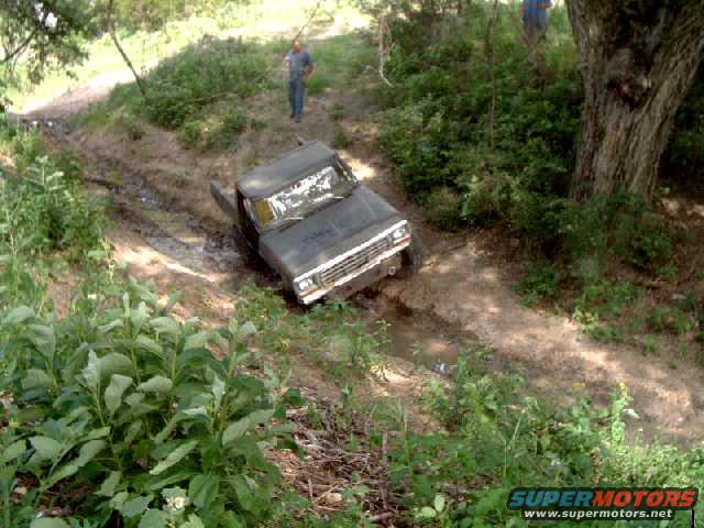 1979 Ford Bronco stuck in a muddy ditch on a dirt trail