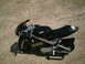 2001 Dodge 2500 - A black mini motorcycle with a racing-style fairing sits on a gravel surface.