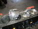 1979 Ford F-150 - Close-up of a piston and connecting rod assembly being fitted into an engine block, showing internal engine components.