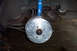 1995 Ford Taurus - Close-up of a car's rear suspension and brake assembly, showing a drilled rotor and a blue Tokico shock.