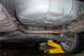 1995 Ford Taurus - The undercarriage of a vehicle is shown, the exhaust pipe, fuel tank, and suspension components.