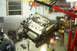 1995 Ford Taurus - An engine is suspended by a red engine hoist in a cluttered garage setting.