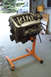 1995 Ford Taurus - Engine on a stand, with a car visible in the background through an open garage door.