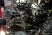 1995 Ford Taurus - A person works on a disassembled engine and transmission assembly in a garage setting.