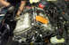 1995 Ford Taurus - Mechanic working on the engine of a vehicle, focusing on the intake manifold and associated components.