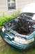 1995 Ford Taurus - The engine bay of a green 1995 Ford Taurus, showing the area where the engine has been removed.