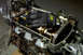 1995 Ford Taurus - Mechanic gloves rest on an engine's internal components, showing the camshaft and timing chain during a refresh or swap.