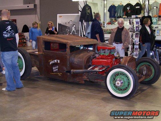 Rat rod pickup truck with red engine and green wheels