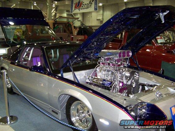 Silver and blue car with exposed chrome engine and purple interior