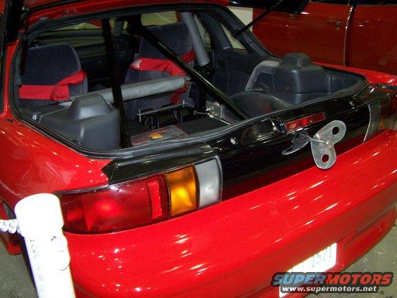 Red car interior with roll cage and racing seats, rear view with wind-up toy key on trunk lid