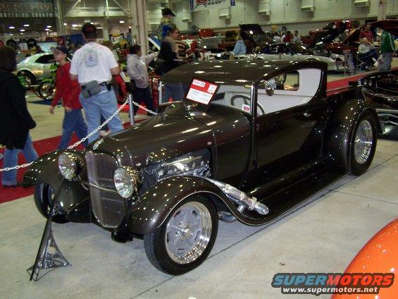 Dark brown hot rod pickup truck with exposed engine and custom wheels