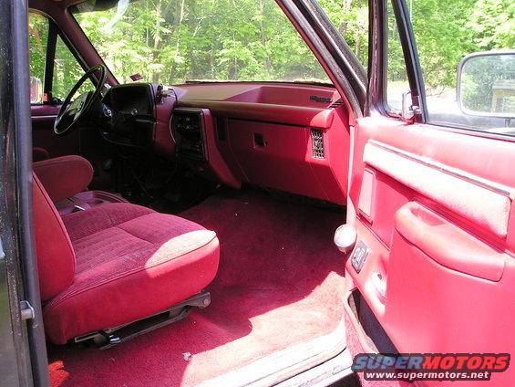 Interior view of a 1988 Ford Bronco with red seats and carpet
