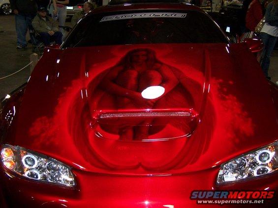 Red sports car hood airbrushed with a woman sitting in a bathtub