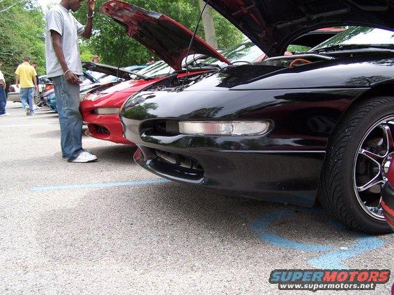 Black 1995 Ford Probe front end, hood open, parked next to red car