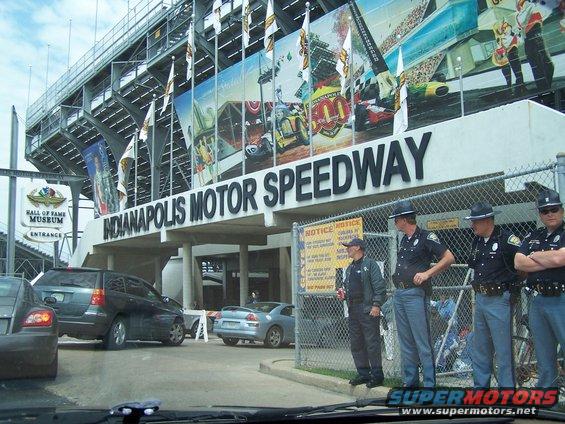 Indianapolis Motor Speedway entrance with police officers and cars in the foreground