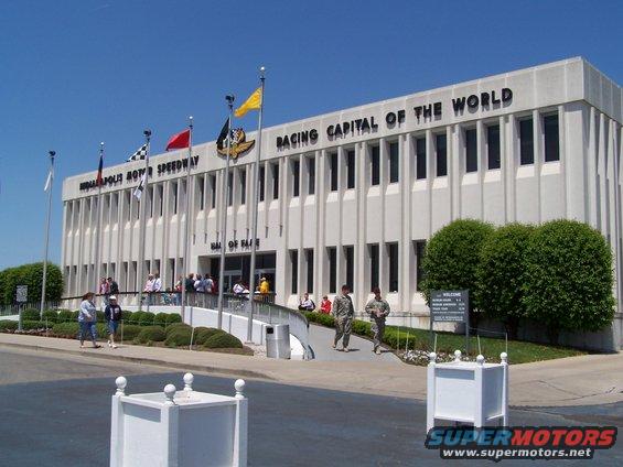 Indianapolis Motor Speedway building with 'RACING CAPITAL OF THE WORLD' text and flags