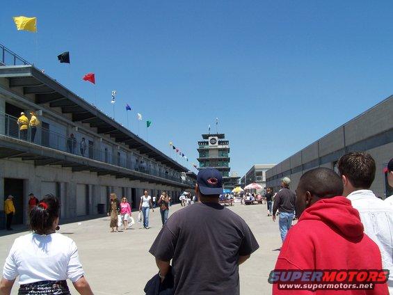 Indianapolis Motor Speedway with flags flying and people walking around