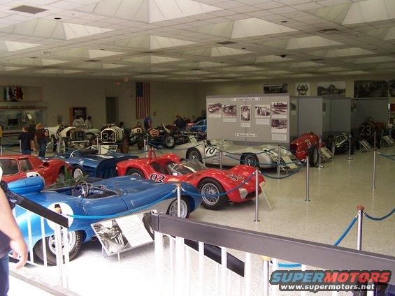Museum display of vintage race cars including a blue open-wheel car with number 1
