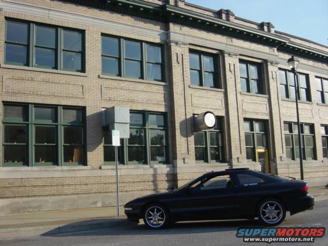 black coupe parked on street in front of brick building