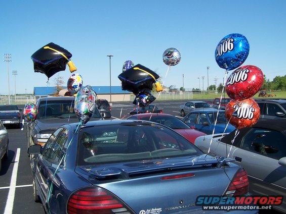 Blue sedan rear view with graduation balloons and '2006' balloons