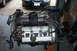 1995 Ford Taurus - Engine assembly on a stand, with black work gloves placed on top of the valve cover.