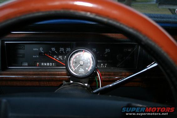 Dashboard interior with aftermarket tachometer and wood grain trim