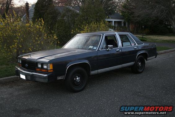 Dark blue sedan parked on a residential street. The car has chrome trim and black wheels