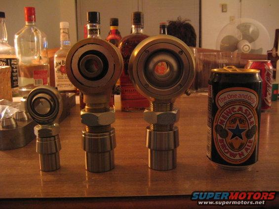 Three metal suspension parts and a Newcastle Brown Ale can on a table