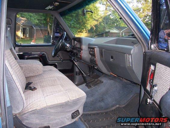 Interior of a pickup truck showing bench seat, dashboard, and steering wheel