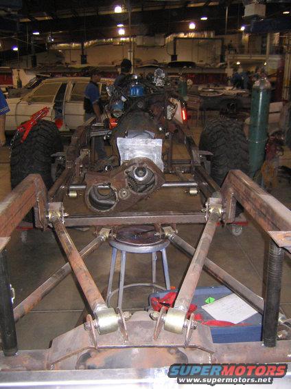 Vehicle chassis with engine and drivetrain parts, viewed from front