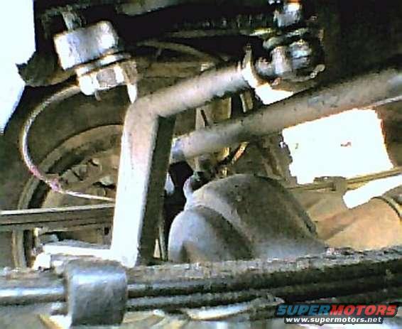 Close-up of vehicle suspension parts including a sway bar and linkage