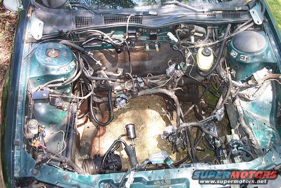 Engine bay stripped bare, showing wiring harness and components