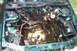 1995 Ford Taurus - Engine bay of a green car, engine has been removed, revealing internal components and wiring.