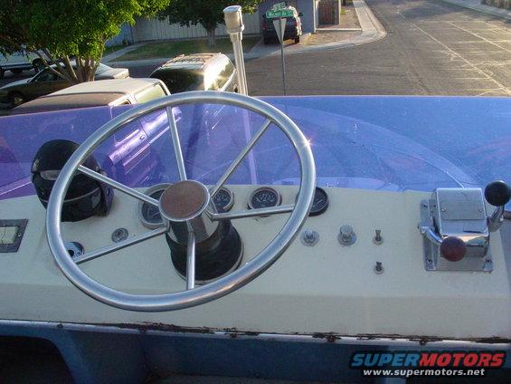 Boat dashboard with chrome steering wheel, gauges, and throttle control