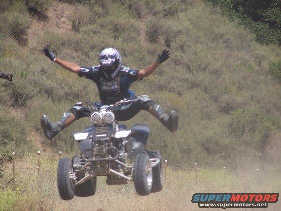 Four-wheeler airborne with rider in mid-air jump