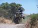 1999 Yamaha WARRIOR - A quad bike rider is captured mid-air during a jump on a dirt track.