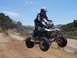 1999 Yamaha WARRIOR - A rider soars through the air on a four-wheeler during a jump on a dirt track.