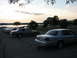2003 Ford Crown Victoria - Several Ford Crown Victorias parked near a lake at sunset.