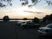 2003 Ford Crown Victoria - Cars parked by a lake at dusk, with trees and a cloudy sky overhead.