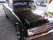 1963 Ford Ranchero - A black 1963 Ford Ranchero is parked on a gravel surface under a covered area.