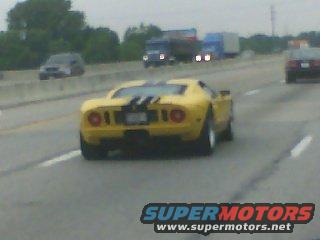 Yellow sports car with black racing stripes on rear